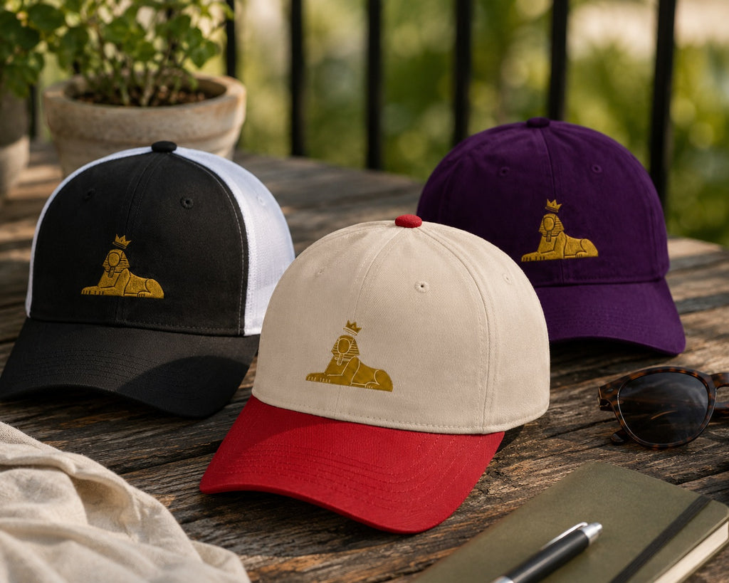BLACK MAJIC caps laid out on a table — natural five-panel, purple and red dad caps