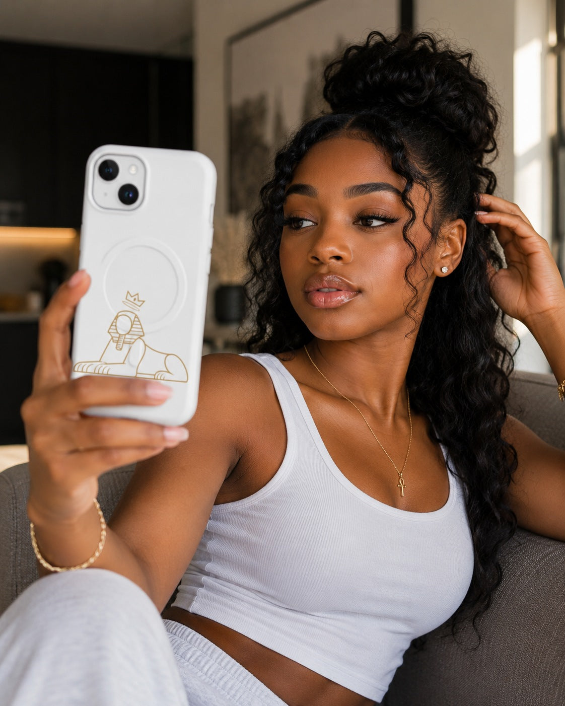 Black woman holding a phone in the BLACK MAJIC MagSafe Tough Case in white, gold crowned Sphinx