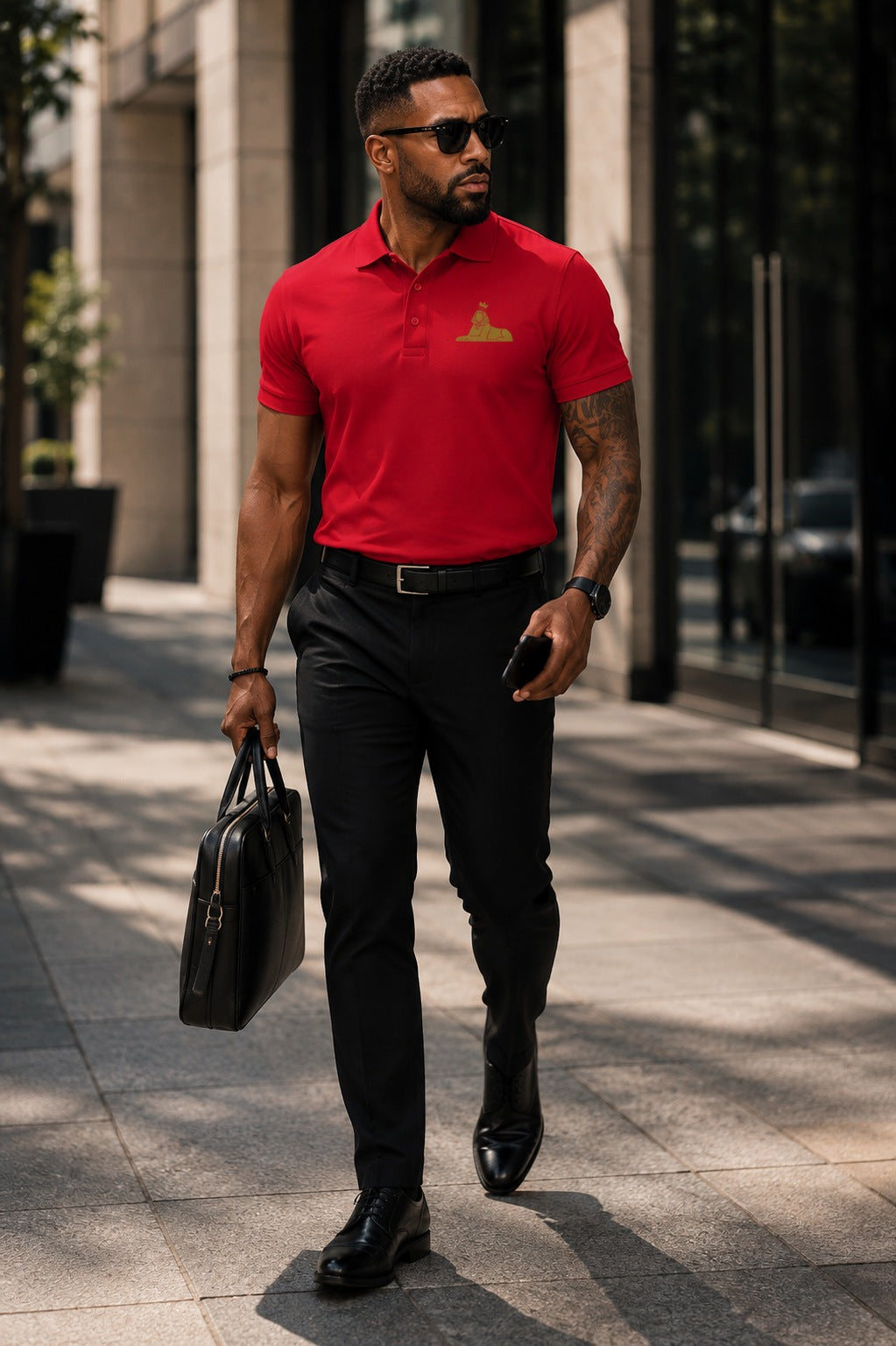 Black man wearing the BLACK MAJIC Adult Crown Polo in Sport Red, gold embroidered crowned Sphinx at the left chest