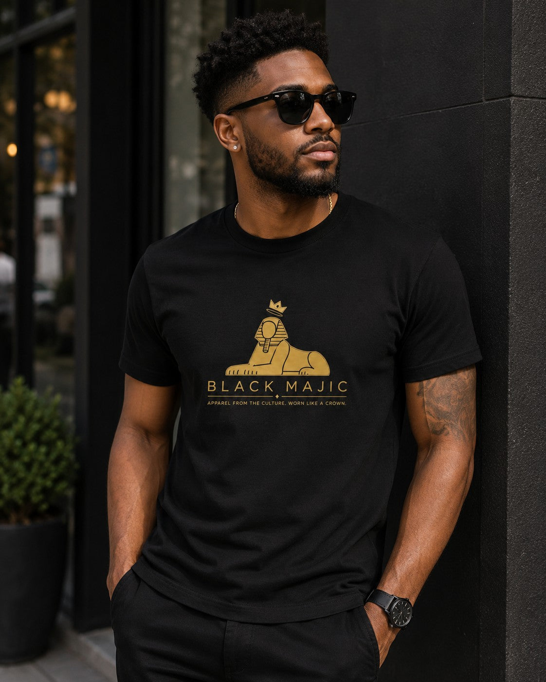 Black man in the BLACK MAJIC Crown Graphic Tee in black on a city street
