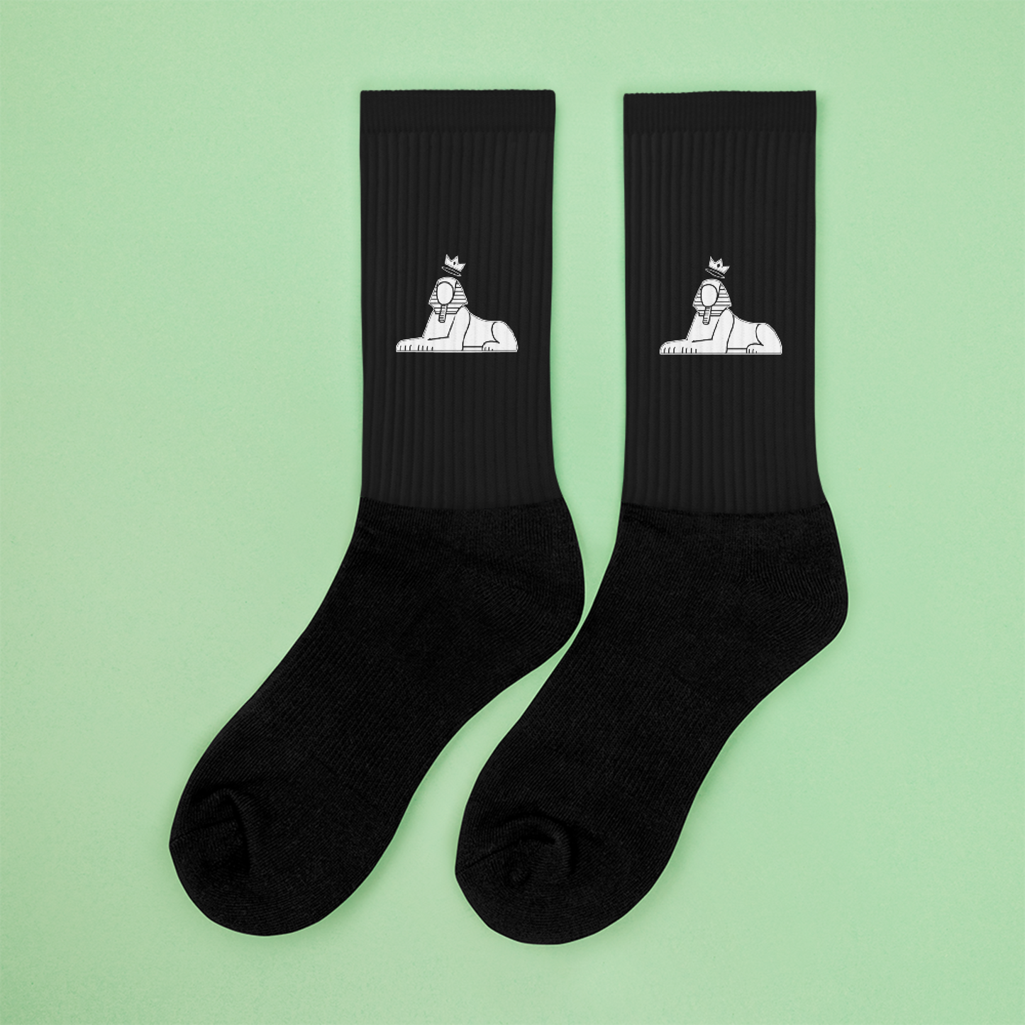 BLACK MAJIC Crown Socks in black, white sphinx mark, flat-lay on mint