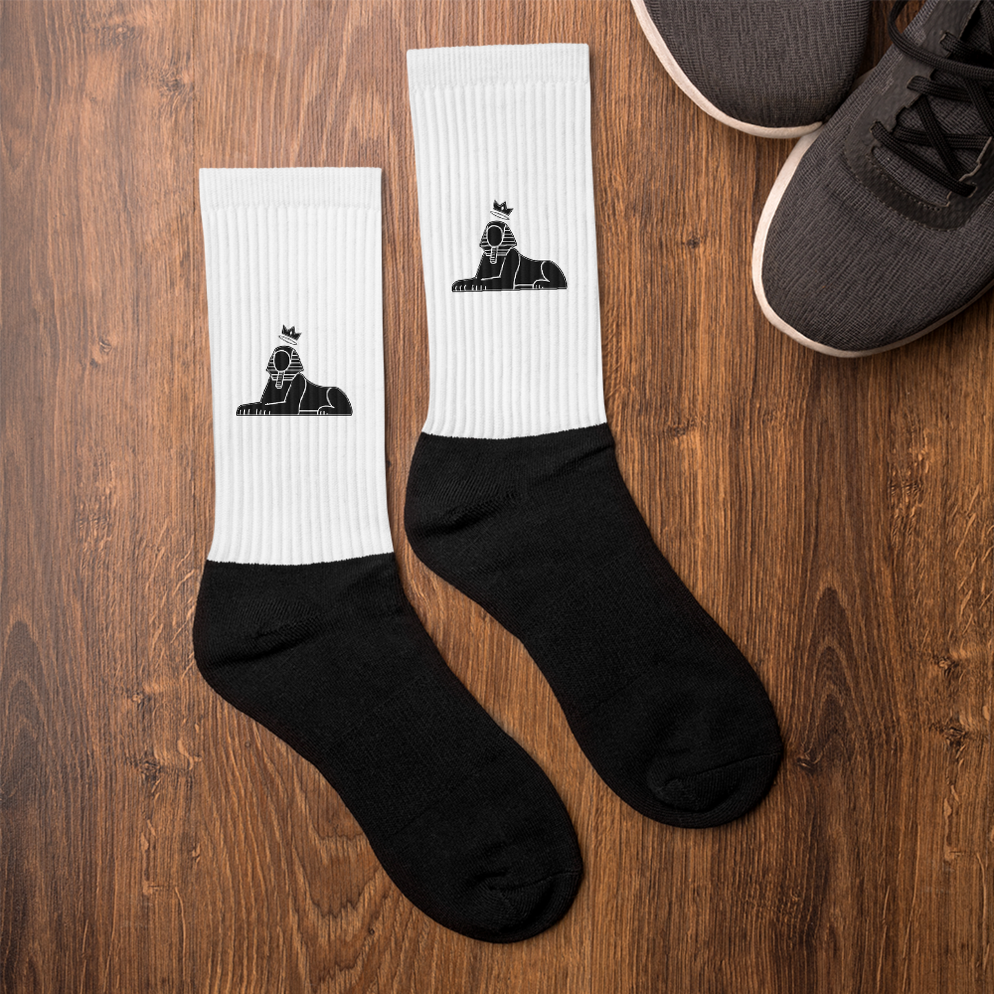 BLACK MAJIC Crown Socks in white laid on a wood floor beside sneakers