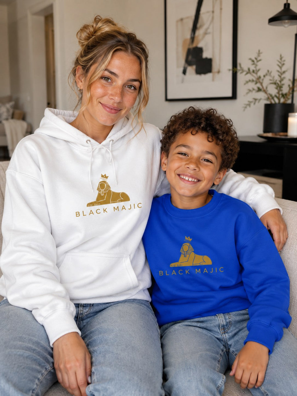 BLACK MAJIC Kids Crown Crewneck in royal blue, gold crowned Sphinx over the wordmark, worn beside the adult Crown Hoodie in white