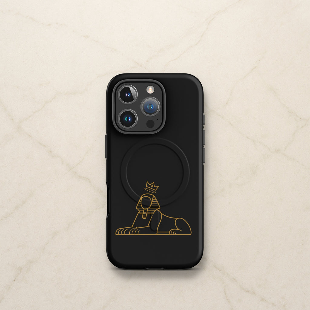 BLACK MAJIC MagSafe Tough Case in black with the gold crowned Sphinx, on a pale marble counter