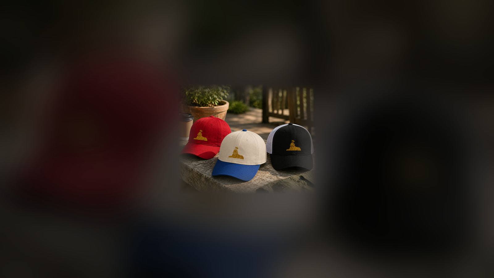 Hats — BLACK MAJIC caps on a stone ledge, gold embroidered crowned Sphinx