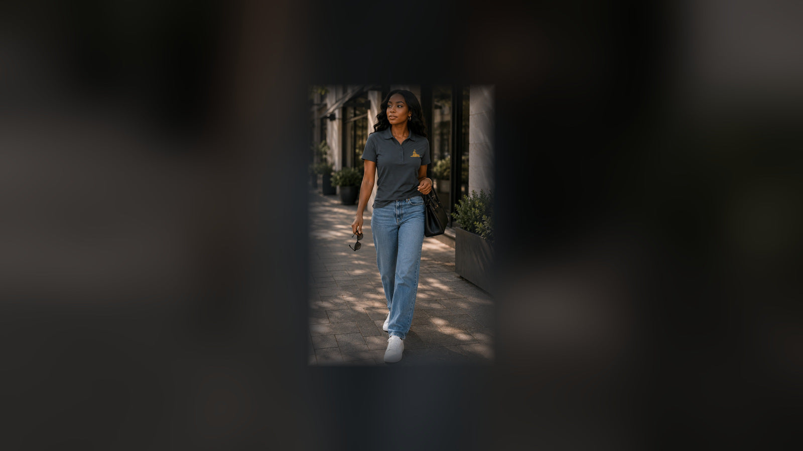 Women's — Black woman walking in the BLACK MAJIC Women's Crown Polo in Storm Grey